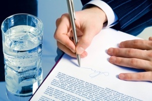 A businessmans hands signing a contract